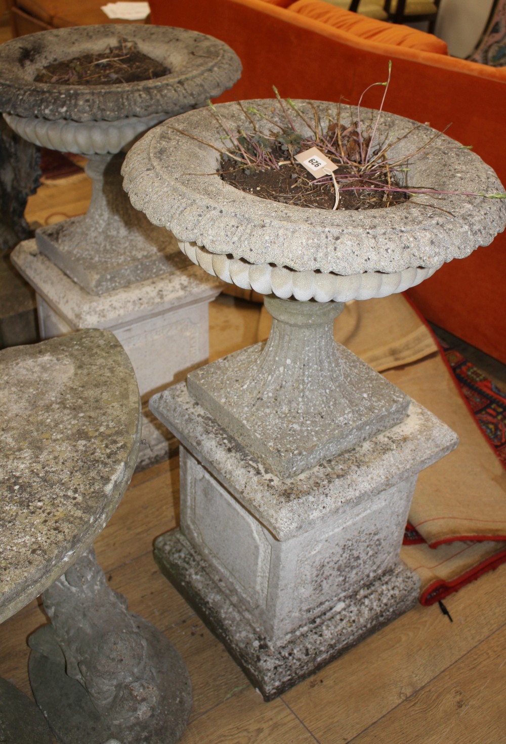 A pair of reconstituted stone campana garden urns on square pedestals, H.94cm Diam.55cm